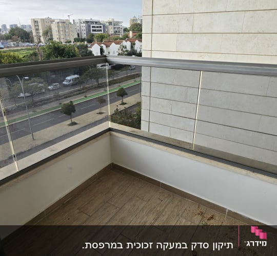 מעקה זכוכית במרפסת עם נוף עירוני